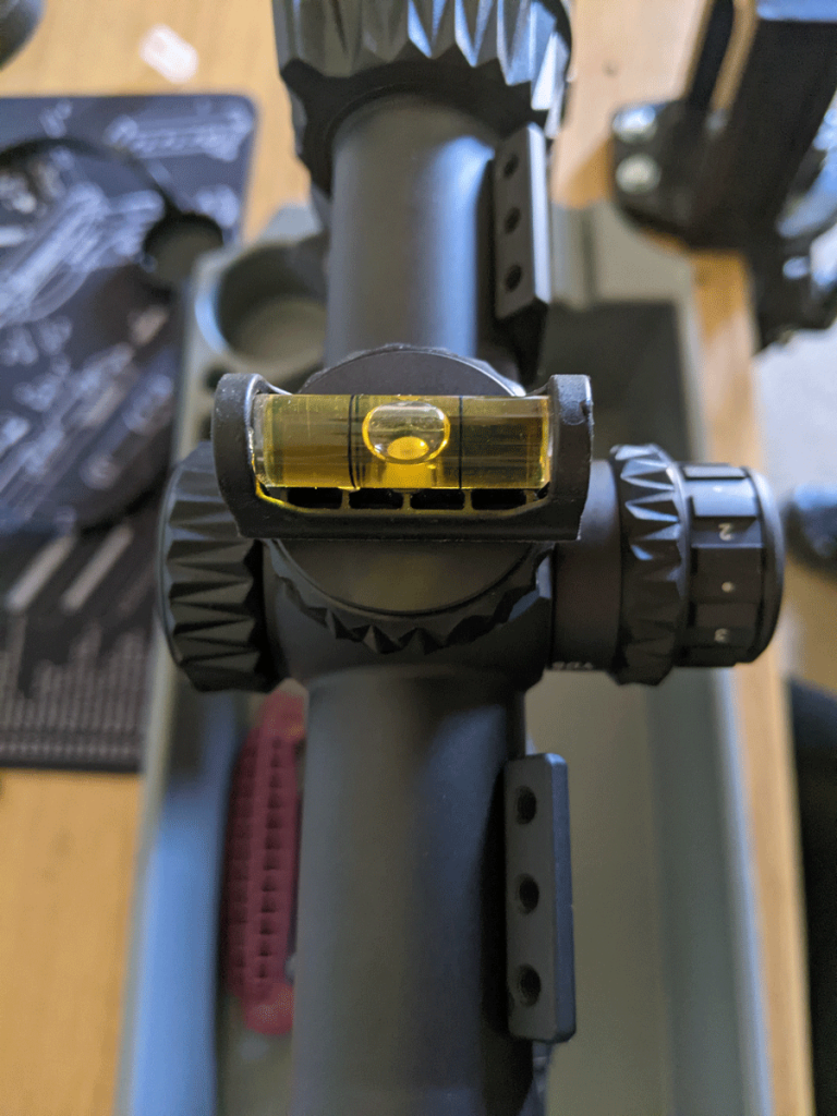 A bubble level on a scope turret to ensure the scope reticle horizon line is perfectly horizontal.